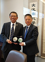 President Rocky Tuan (left) presents a souvenir Director Jiang Jianxiang